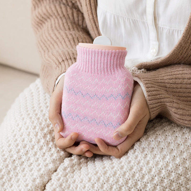 Bouillotte tricotée tenue entre les mains