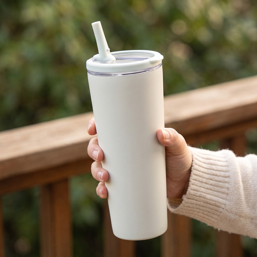 Gobelet isotherme 850 ml tenu en main, paille sortie, en extérieur