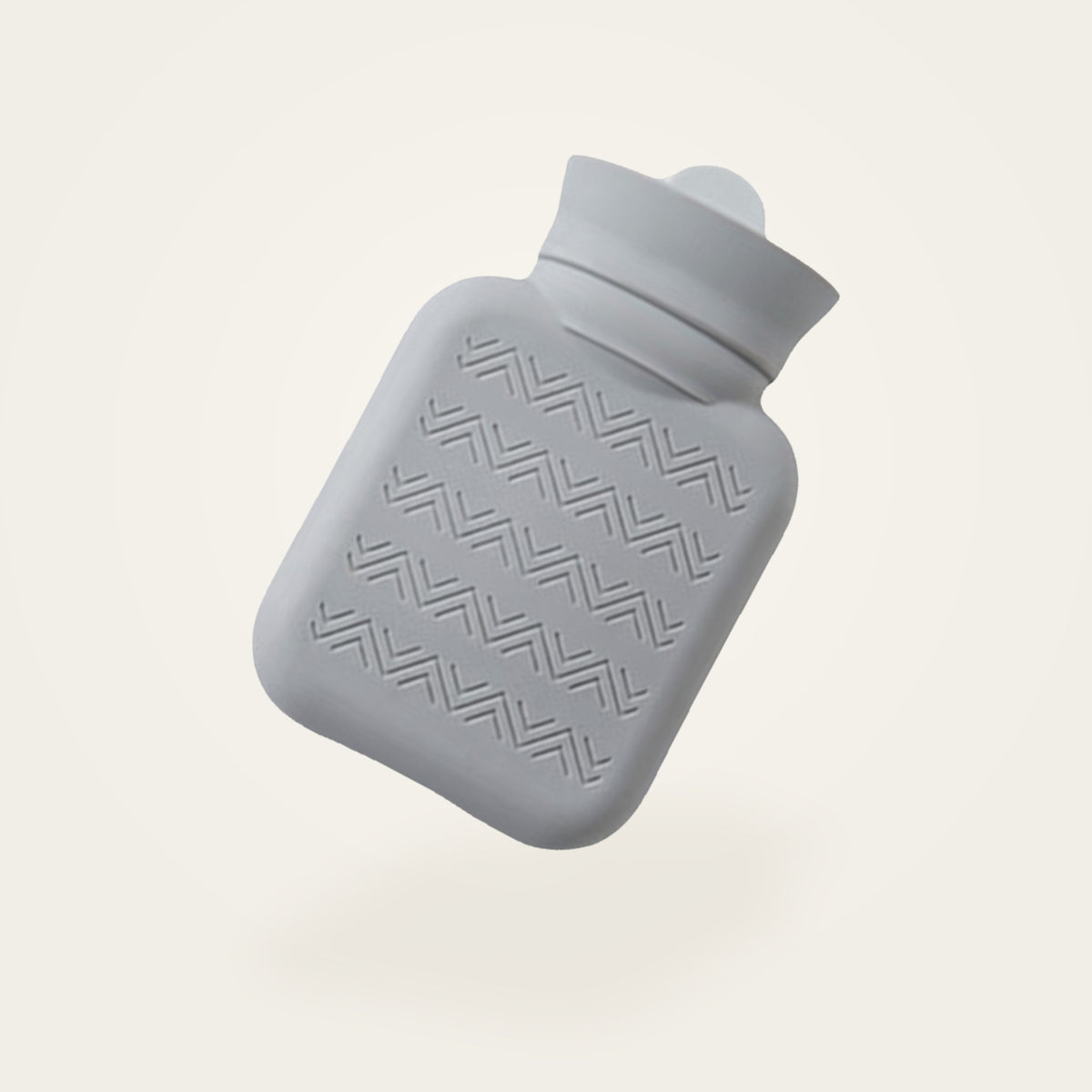 Bouillotte à eau en silicone gris clair, sans sa housse, fond crème