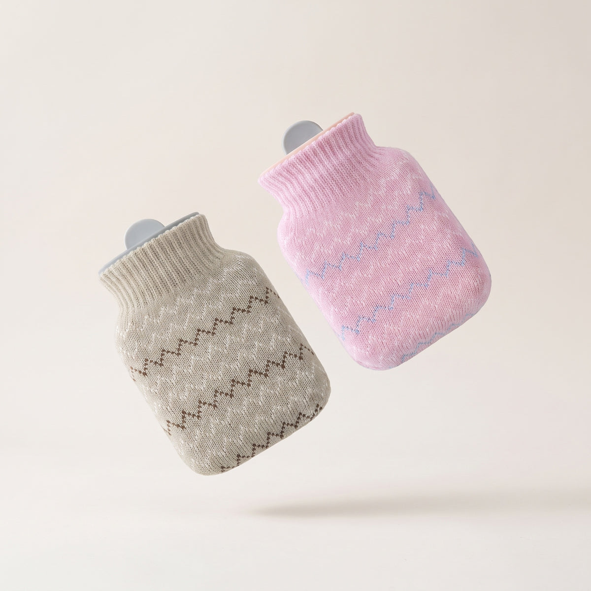 Bouillotte à eau Hélios avec deux housses tricotées amovibles, gris clair et rose, fond crème