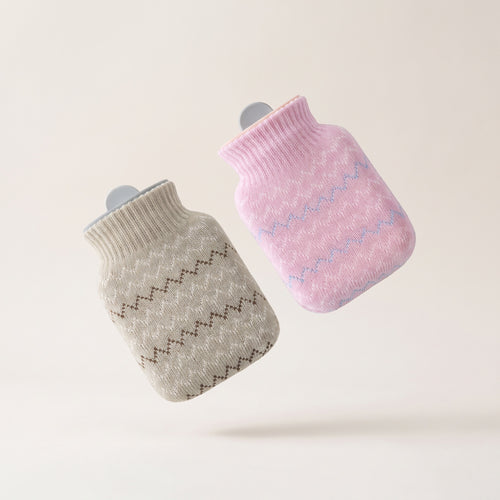 Bouillotte à eau Hélios avec deux housses tricotées amovibles, gris clair et rose, fond crème