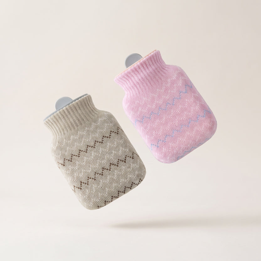 Bouillotte à eau Hélios avec deux housses tricotées amovibles, gris clair et rose, fond crème