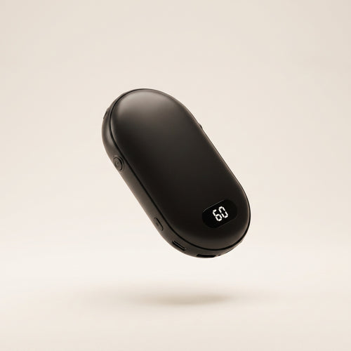 Galet chauffe-mains rechargeable noir avec écran LED, vue de trois quarts sur fond crème