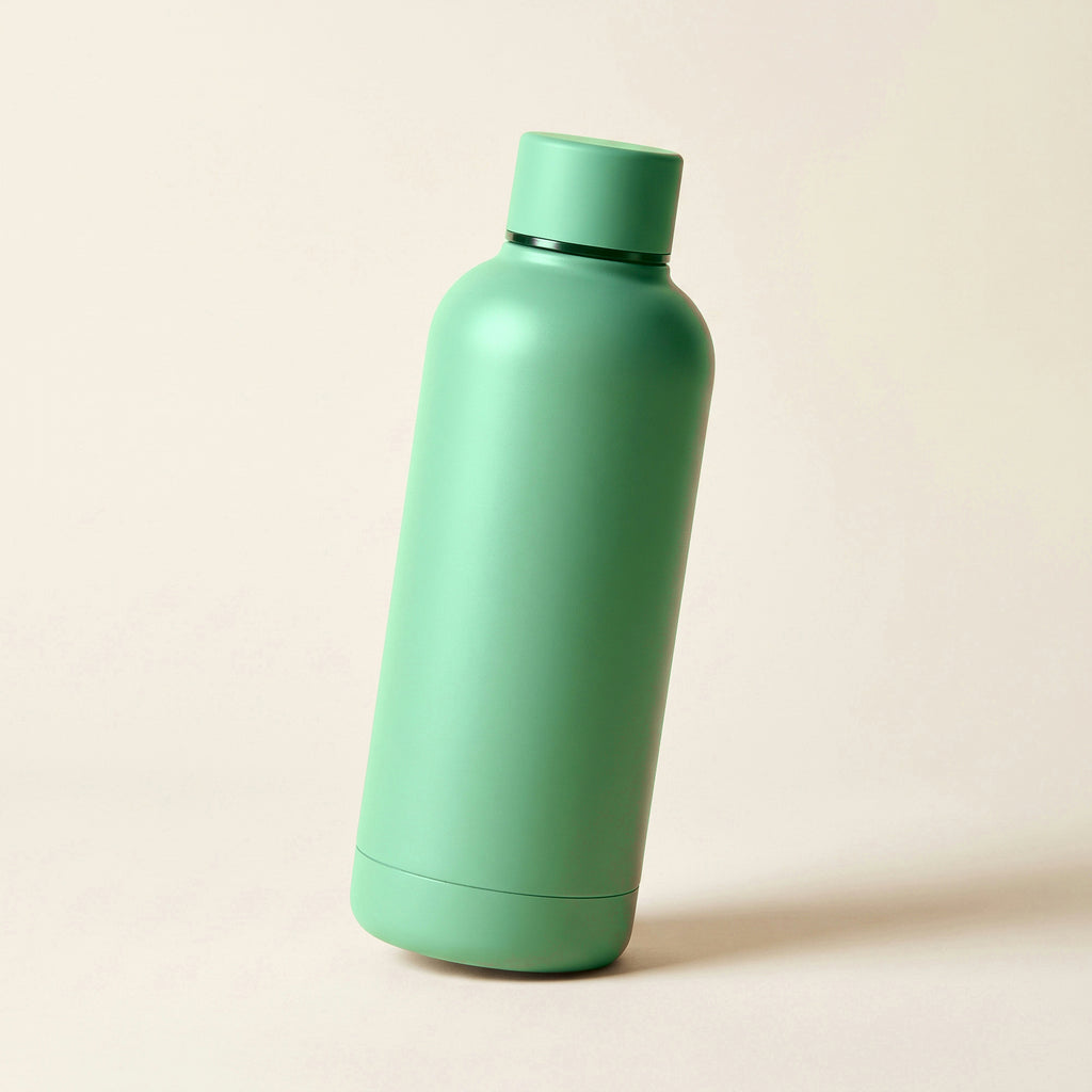 Gourde isotherme soft-touch vert-de-gris 500 ml posée sur fond crème