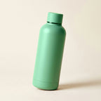 Gourde isotherme soft-touch vert-de-gris 500 ml posée sur fond crème