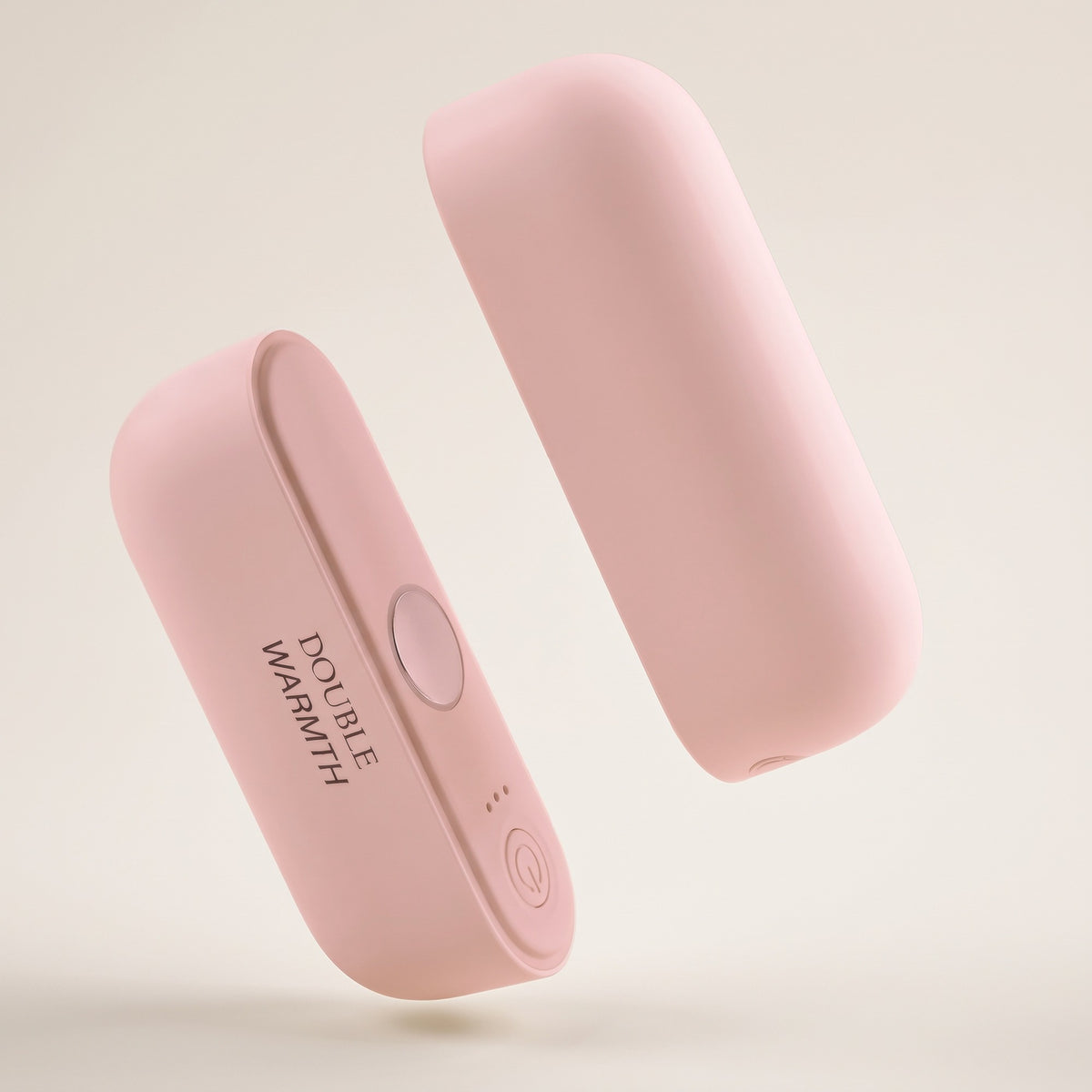 Chauffe-mains magnétique rose, les deux blocs séparés sur fond crème