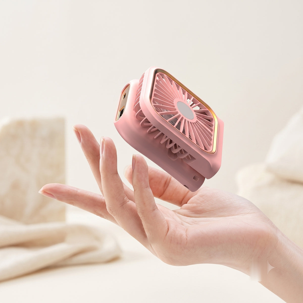 Ventilateur pliable 3-en-1 Power Bank Hélios coloris rose, tenu en main