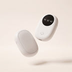Chauffe-mains de poche blanc en deux modules, écran de réglage allumé, fond crème