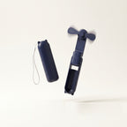 Ventilateur de poche pliable Hélios, coloris Bleu Marine, vue plié et déplié, fond crème
