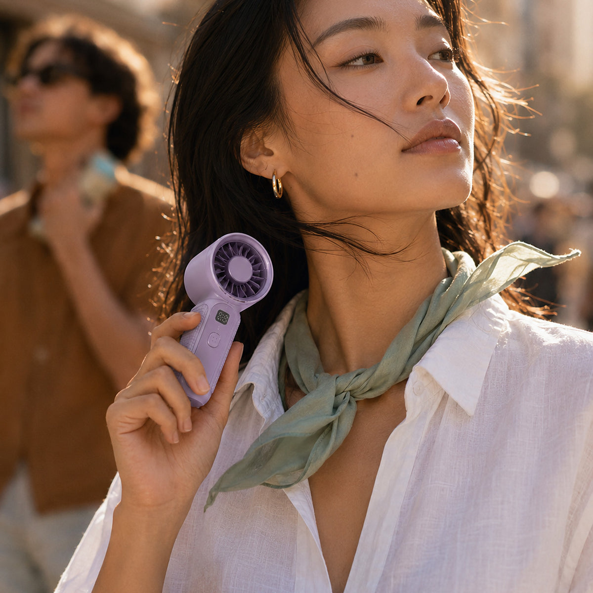 Mini ventilateur de poche Hélios coloris violet, tenu à la main en ville
